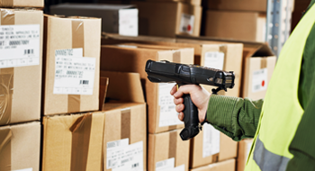 A picture of a worker scanning a box in a warehouse